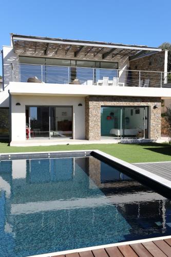 une maison avec une piscine devant dans l'établissement Villa NAOUSSA vue mer proche plage, à Carqueiranne