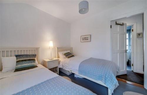 a bedroom with two beds and a night stand with two beds at Cosy Ramelton Cottage in Ramelton