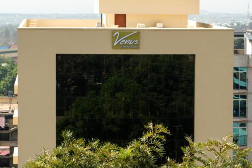 a building with a vivas sign on it at Venus Premier Hotel in Arusha