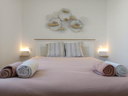 une chambre avec un grand lit avec des serviettes dessus dans l'établissement Appartement cosy avec parking proche vieux port, à Pornic