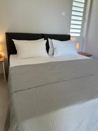 a large bed with white pillows at 76 Morc La Fleche in Midlands Station