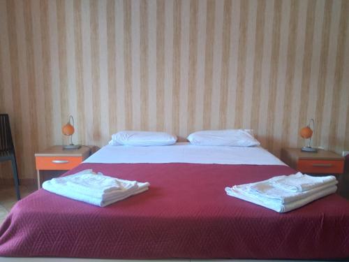 a bedroom with a bed with two towels on it at Madogi Style Camera in SantʼAngelo di Brolo