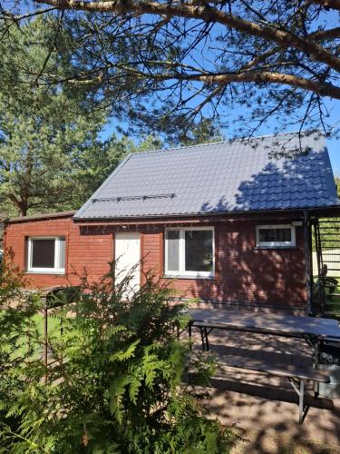 a red brick house with a picnic table in front of it at Домик с сауной для отдыха in Katase