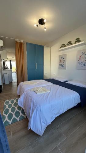 a bedroom with two beds with blue cabinets and a rug at Anton Court in Xlendi