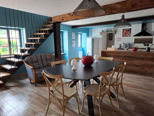 a dining room with a table and chairs and a staircase at GÎTE chez la petite marie à 40 mn du PUY DU FOU in Moncoutant