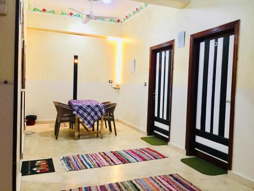 a dining room with a table and two doors at sun smile guest house᭄ꦿ in Luxor
