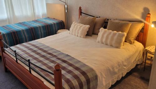a bedroom with a large bed with white sheets and pillows at Vintažys studeja in Rēzekne