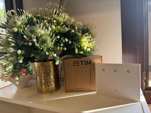 a vase of flowers on a table next to a laptop at Reggio Emilia Apartments - Giardino - Uno in Reggio Emilia