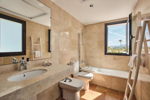 a bathroom with a sink and a toilet and a tub at Luxe villa met privézwembad & zeezicht - Villa Luna in Sant Josep de Sa Talaia