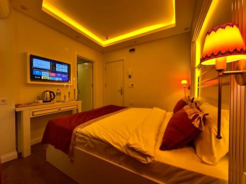 a bedroom with a large bed and a television at Ayasofya Hotel - Special Class in Istanbul