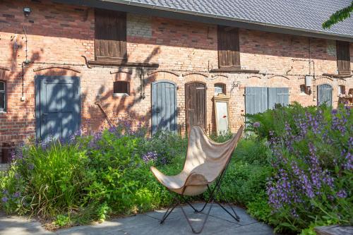 a chair in a garden in front of a brick building at Alte Flachsfarm in Cottbus