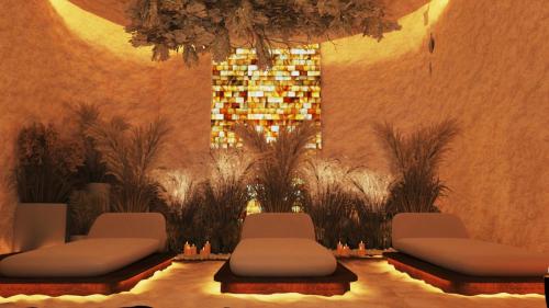 a room with two chairs and a wall with plants at Royal G Max in Golem