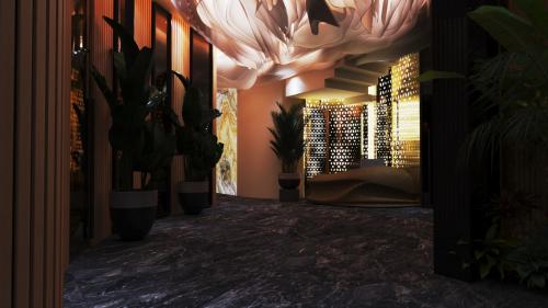a hallway with plants and a room with a couch at Royal G Max in Golem