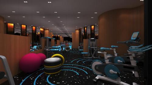 a gym with many rows of exercise equipment at Royal G Max in Golem