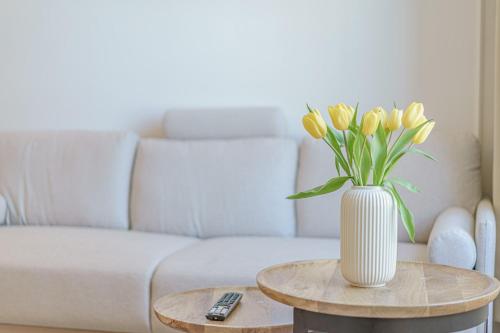 a vase of yellow tulips sitting on a table at Modern Apartament near city centre in Perth