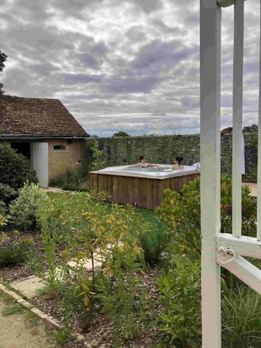 a garden with a roof with two birds sitting on it at Maison de vacances avec piscine chauffée, jacuzzi et jardin privé - proche circuit des 24h du Mans in Saint-Christophe-en-Champagne