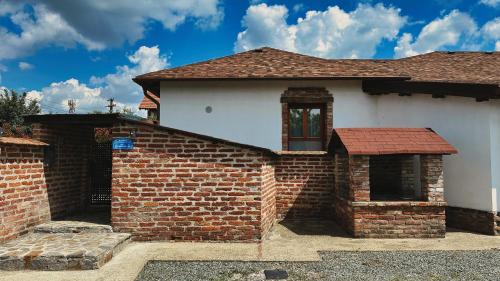 a house with a brick wall and a window at NEO's Ark - retreat in Giarmata
