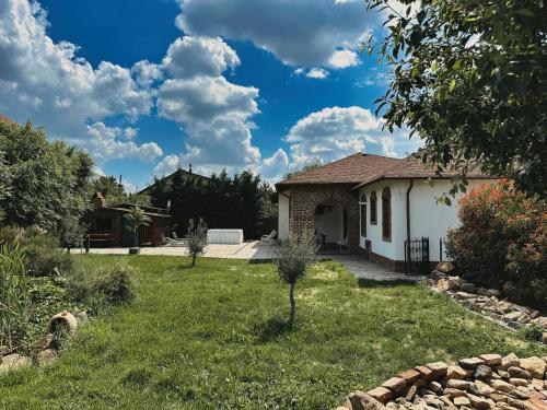 a house in a yard with a grass yard at NEO's Ark - retreat in Giarmata