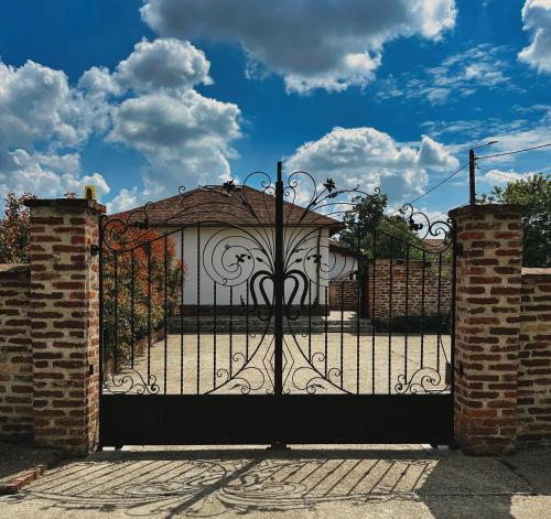 a gate to a driveway with a white gate with a gate at NEO's Ark - retreat in Giarmata