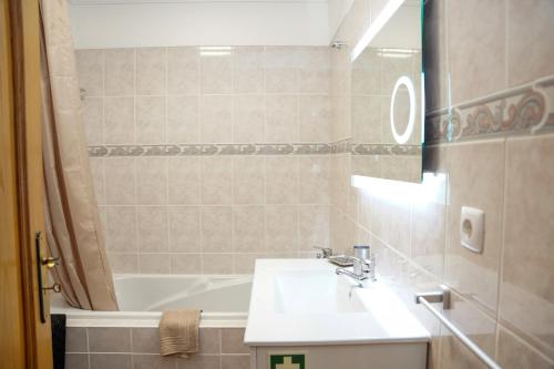 een badkamer met een wastafel en een ligbad bij Rosária Flat in Santa Cruz