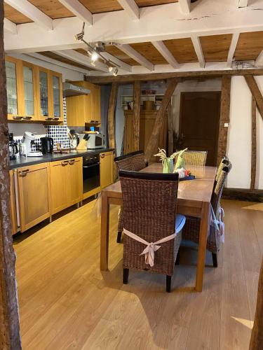 Il comprend une cuisine avec une table et des chaises en bois. dans l'établissement Greenhouse, à Quilen