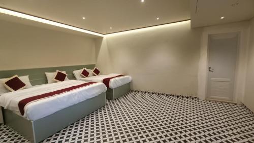 a bedroom with two beds and a door in it at kmslegacy in Jāmb