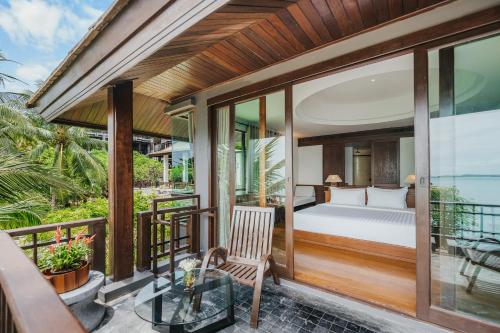 a bedroom in a villa with a bed on a balcony at The Kala in Amphoe Koh Samui