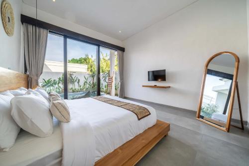a bedroom with a large bed and a large window at Peaceful 2BR Pool Villa in Kerobokan - V2 in Kerobokan
