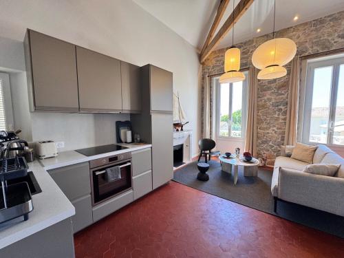 une cuisine avec des armoires blanches et un salon dans l'établissement Modern apartment near beaches & restaurants, à Carqueiranne