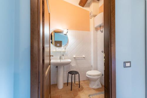 a bathroom with a sink and a toilet and a mirror at Masseria del bosco Poderuccio in Chianciano Terme