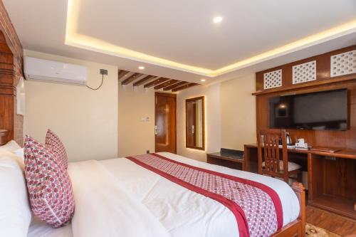 a bedroom with a bed and a desk and a television at Amarawati Boutique Hotel in Kathmandu