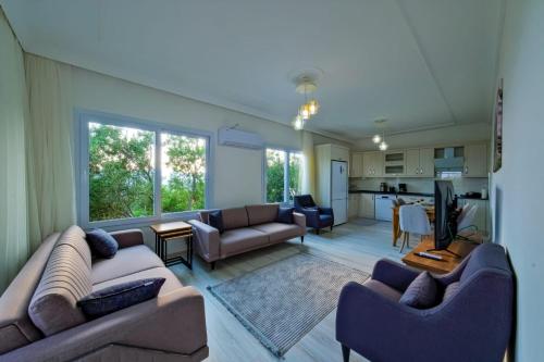 a living room with two couches and a kitchen at Umut villa in Göcek