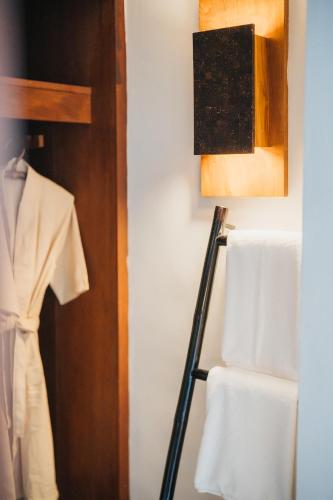 a closet with a rack of towels and a robe at The Kala in Amphoe Koh Samui