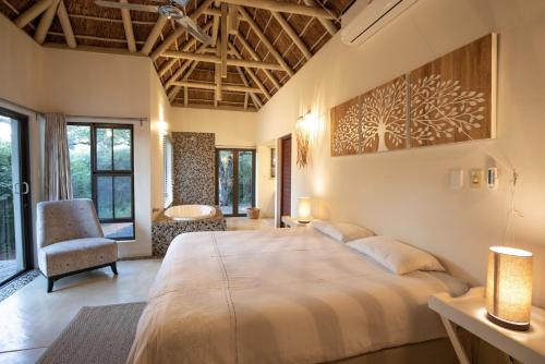 フッドスプルイトにあるVilla Blaaskansの大きなベッドと椅子のある寝室