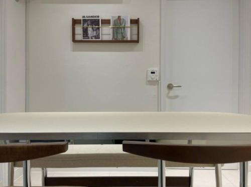 a white table with two chairs in front of a door at Harangae in Seoul