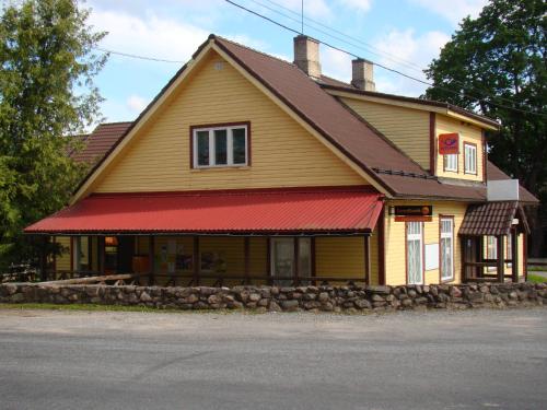 a yellow house with a red roof at Kõrtsitalu külalistemaja in Kõpu