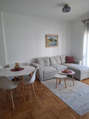 un soggiorno con un divano e un tavolo di Apartman Astra a Trebinje