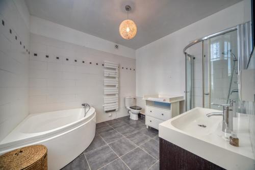 une salle de bain avec une baignoire, des toilettes et un lavabo dans l'établissement R'Apparts T4 Le Prieuré, à Grenoble