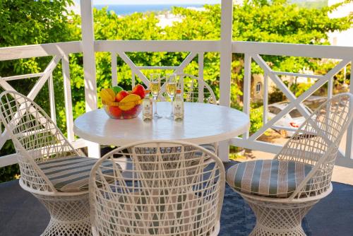 a white table with two chairs and a bowl of fruit at Czar's Citadel-2 Bedroom Apt 23E at Columbus Heights Ocho Rios in Ocho Rios