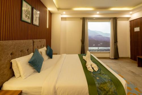 a bedroom with a large bed with a window at HOLYWATER Hotel by Ganga Kinare #150 mts from Ganga Ghat Rishikesh in Rishīkesh