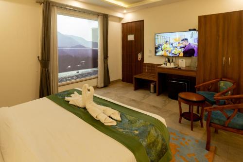 a hotel room with a towel animal on the bed at HOLYWATER Hotel by Ganga Kinare #150 mts from Ganga Ghat Rishikesh in Rishīkesh