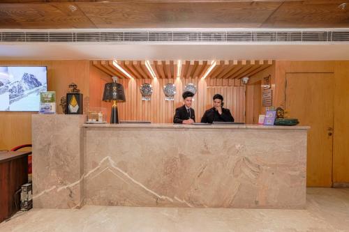 two men sitting at a bar in a restaurant at Quality Inn Elite Levelup Boutique in Amritsar
