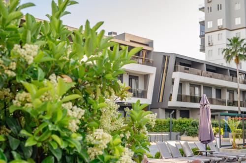 an umbrella and chairs in front of a building at Glory Life in Antalya