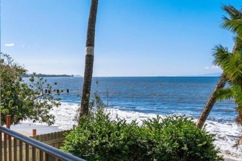 a view of the beach with palm trees and the ocean at KIHEI BEACH, #210 condo in Kihei