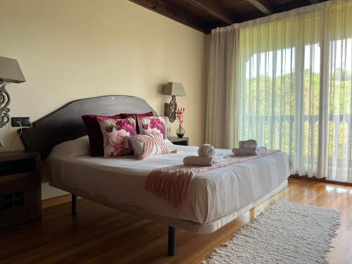 a bedroom with a large bed with a large window at Casona Asturiana Casa Delfa in Cervera