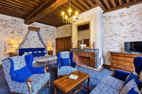 a living room with blue chairs and a fireplace at Grand Hôtel Montespan Talleyrand in Bourbon-lʼArchambault