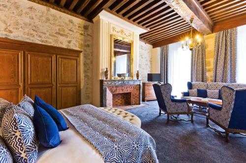 - une chambre avec un lit, un bureau et une cheminée dans l'établissement Grand Hôtel Montespan Talleyrand, à Bourbon-lʼArchambault