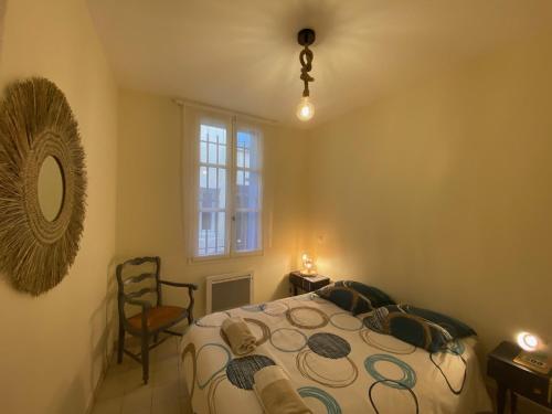 une chambre avec un lit, une fenêtre et une chaise dans l'établissement La loge d'Avignon, à Avignon