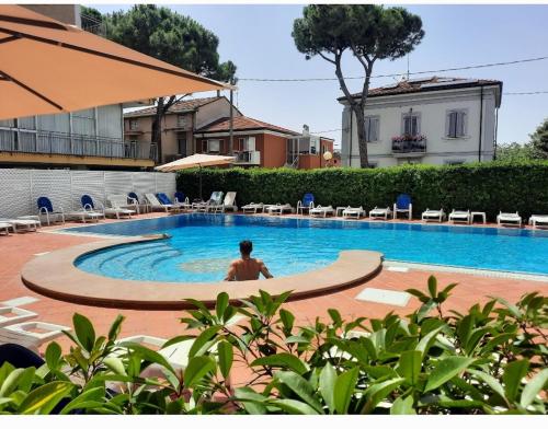 a man is sitting in a swimming pool at Hotel Ricchi in Rimini