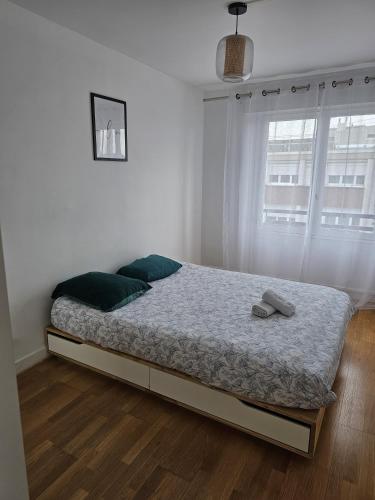 Ce lit se trouve dans une chambre blanche dotée d'une fenêtre. dans l'établissement Élégant 3 pièces proche Paris La Défense, à Bezons